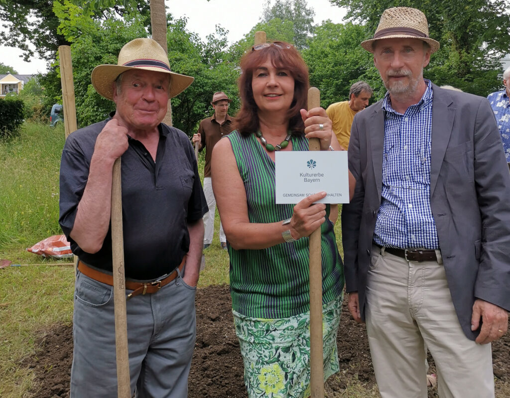 Drei Helfer von Kultur Erbe Bayern beim Restaurieren des Seidlparks in Murnau