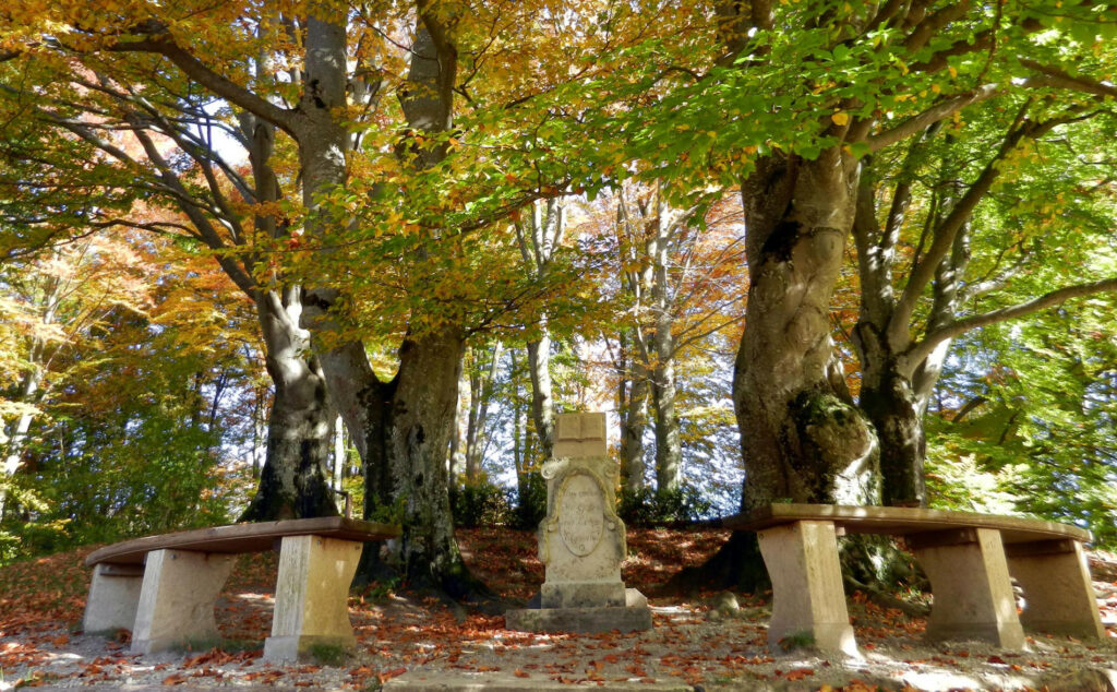 Monument und zwei Steinbänke im Seidlpark in Murnau im Herbst